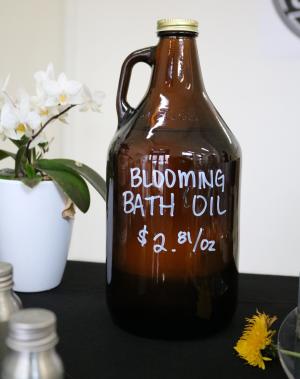 Brown bottle of bath oil with dandelion in the foreground